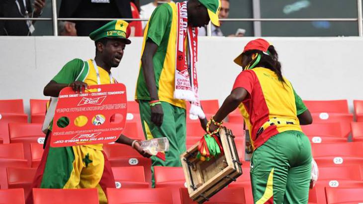 Сенегальцы убирают за собой мусор на стадионе